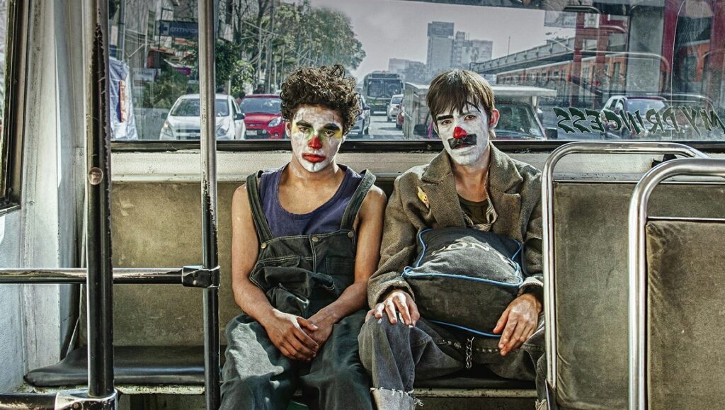 Chicuarotes film still. Two young clown-faced characters on a bus in Mexico City. Gael Garcia Bernal film.