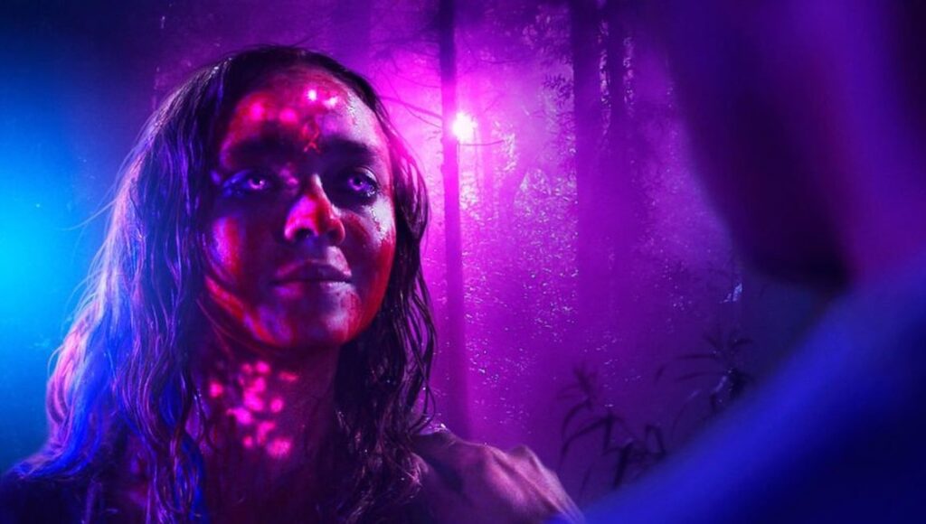 Color Out of Space | Richard Stanley Woman with glowing eyes in Color Out of Space, a Richard Stanley film. Purple and blue lighting.