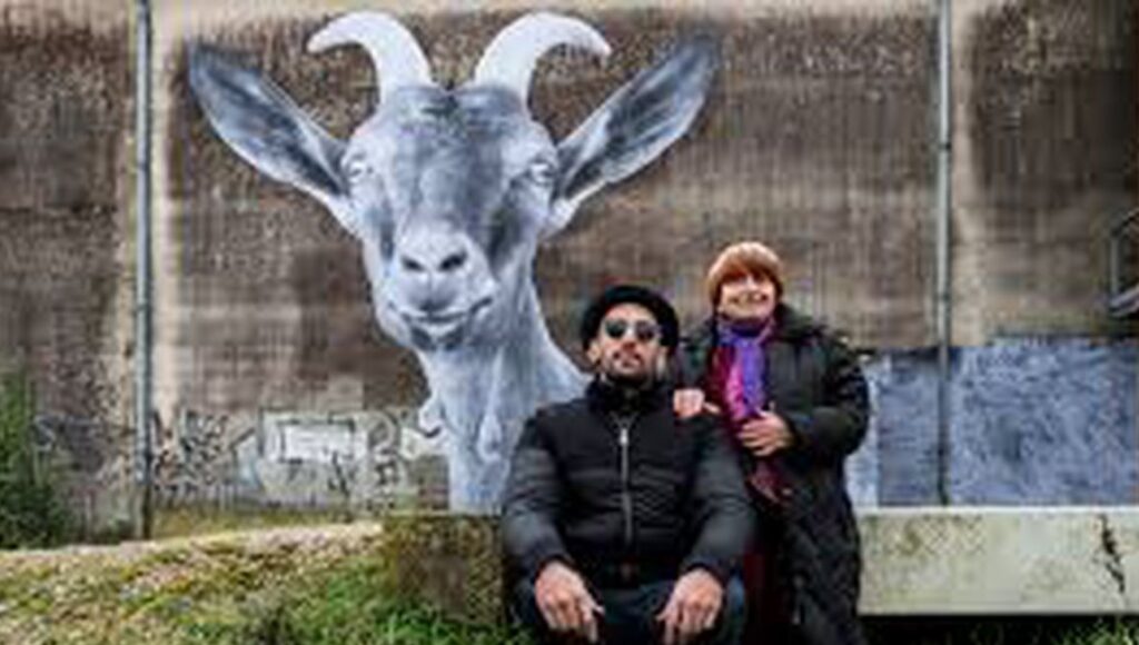 Agnes Varda & JR Faces Places film still. JR and Varda pose with a goat mural.