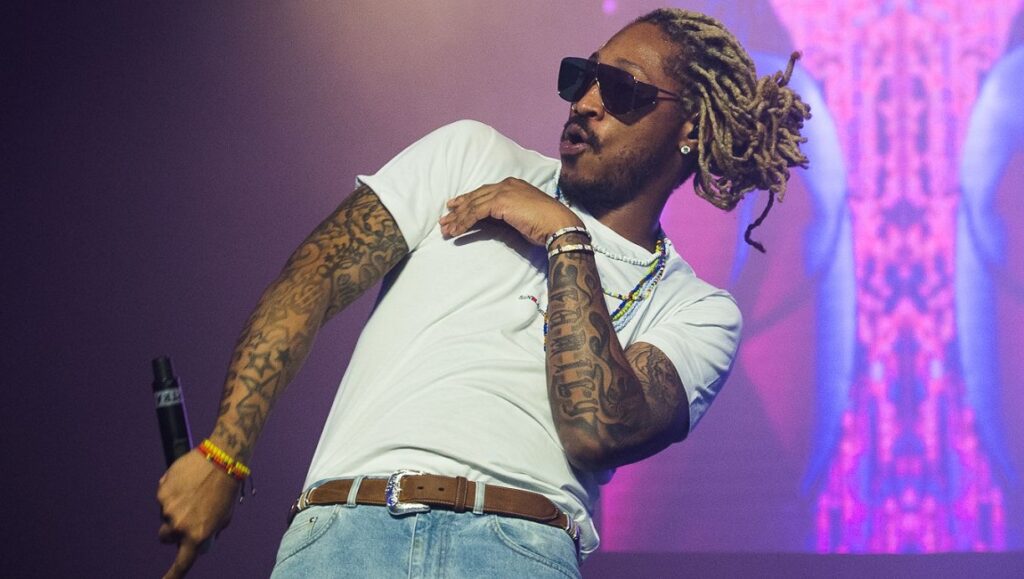 Future | High Off Life Future performing live. Rapper with sunglasses, dreadlocks, and tattoos on stage. High Off Life album.