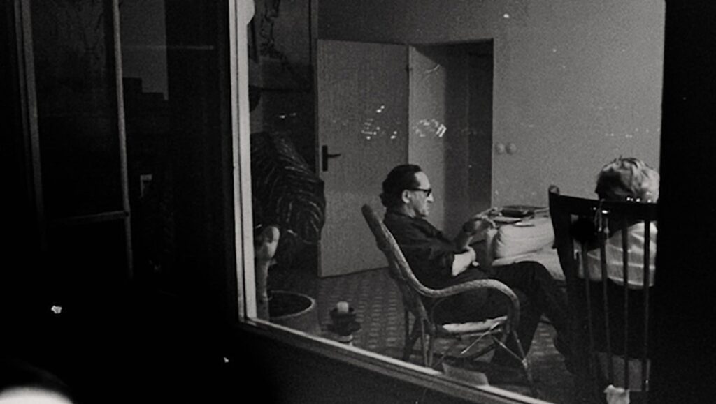 Heimat Is a Space in Time still: Black and white photo of people indoors. Thomas Heise film.