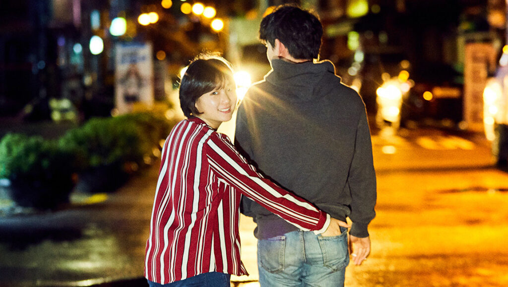 Hit the Night | Jeong Ga-young Jeong Ga-young's Hit the Night film still. Woman playfully puts hand in man's pocket on a city street at night.