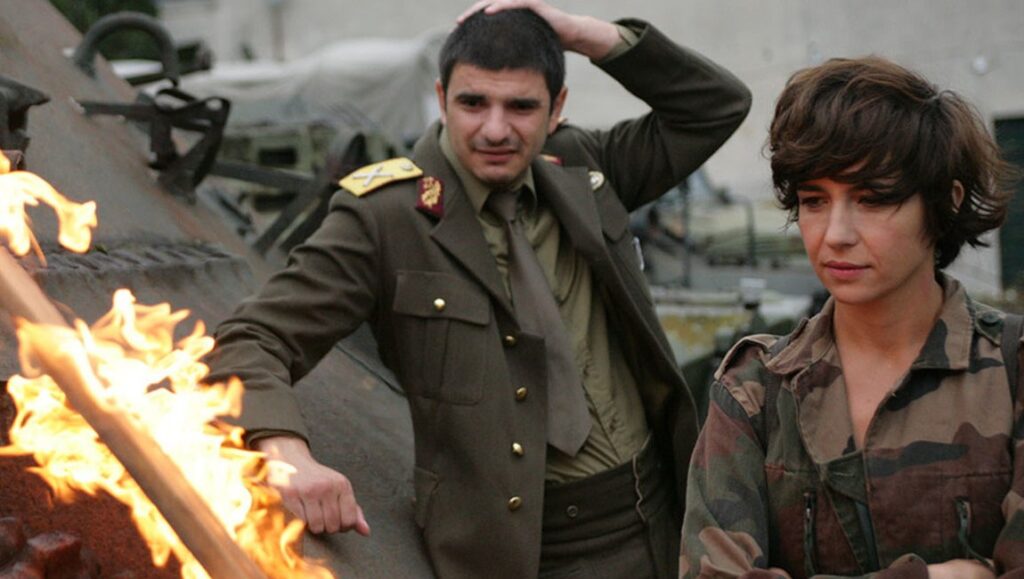 I Do Not Care If We Go Down in History as Barbarians | Radu Jude I Do Not Care If We Go Down in History as Barbarians movie scene. Actors in military attire by a fire.