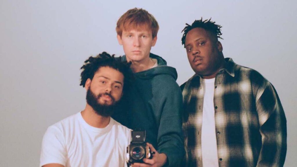 Injury Reserve | Injury Reserve Injury Reserve band portrait. Group members pose with a vintage camera. Hip-hop music group.