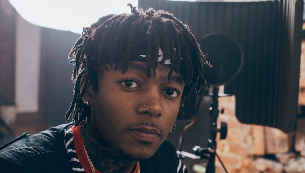 J.I.D., rapper and artist. DiCaprio 2 album. Portrait of J.I.D. with dreadlocks and bandana.
