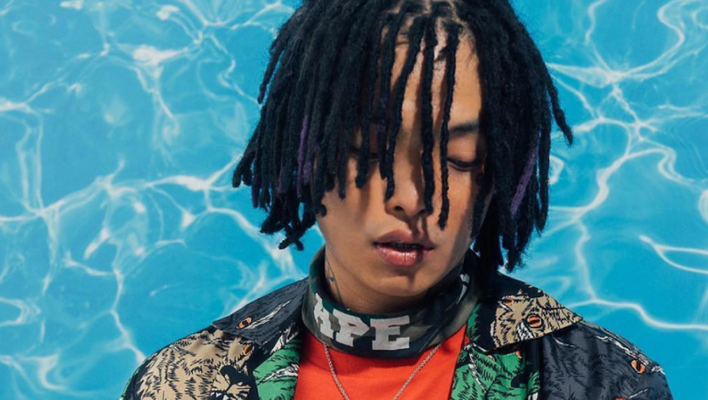 Keith Ape | Born Again Keith Ape, Born Again album art. Rapper with dreadlocks, APE logo neck, and patterned shirt. Blue water background.