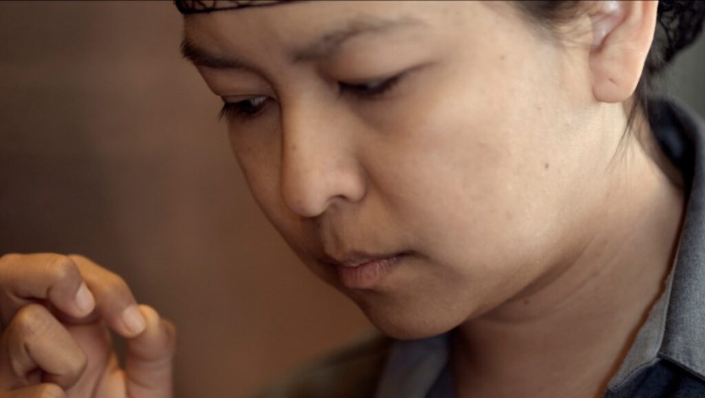 Close-up of Eve, The Chambermaid, looking down. Lila Aviles film character.
