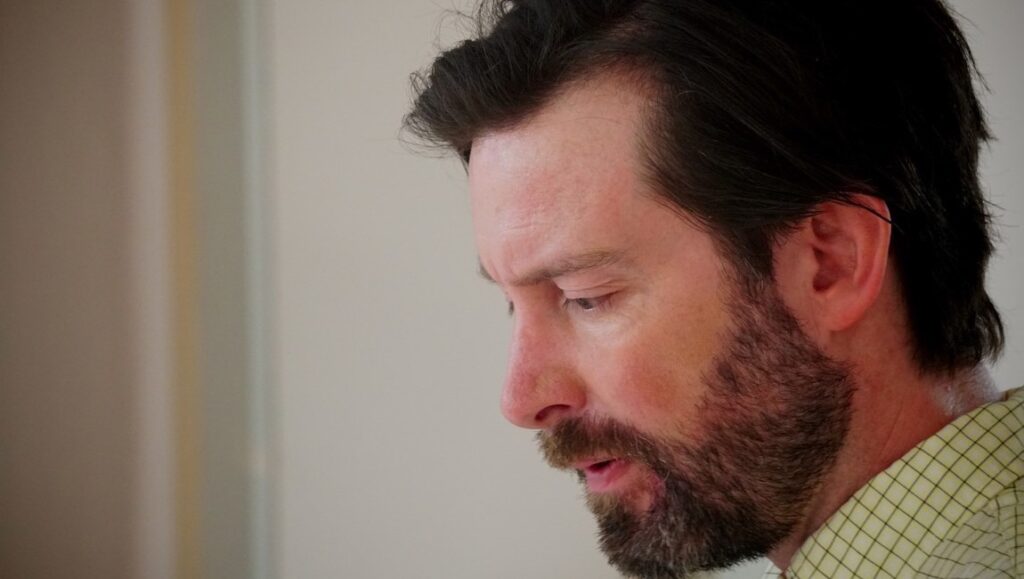 The Dead Center | Billy Senese Billy Senese's The Dead Center film promo image. Close-up of a man with a beard, looking down.