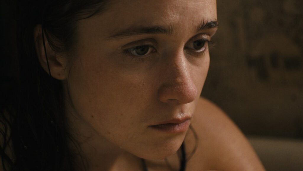 Them That Follow | Britt Poulton & Dan Madison Savage Close up of Alice Englert in Them That Follow movie. Intense, dramatic lighting.