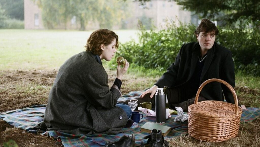 Still from The Souvenir by Joanna Hogg. Couple on picnic blanket, wicker basket, thermos. Period drama.