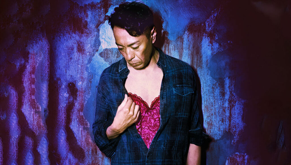 Jun Li as Tracey. Man in unbuttoned shirt with pink lace. Transgender film.