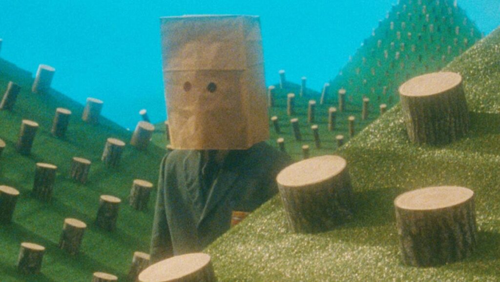 The Twentieth Century | Matthew Rankin Still from The Twentieth Century by Matthew Rankin. Person with paper bag over head in surreal landscape.