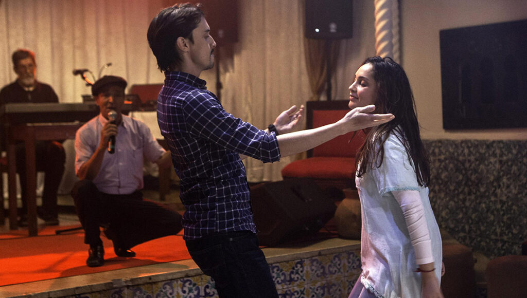 Until the Birds Return | Karim Moussaoui Karim Moussaoui's Until the Birds Return film scene. Man touches a woman's face, musicians perform in the background.