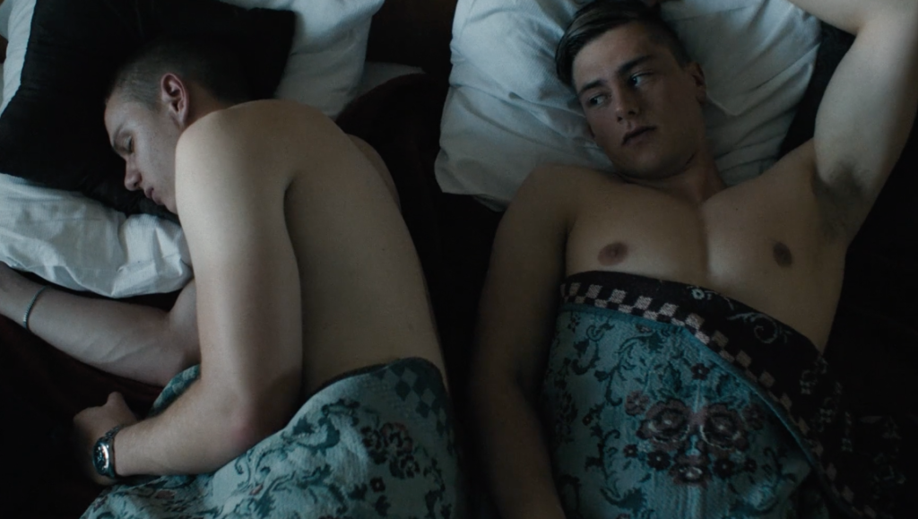 Beach Rats film still: Two shirtless men in bed. One sleeps, the other is awake. Eliza Hittman film.