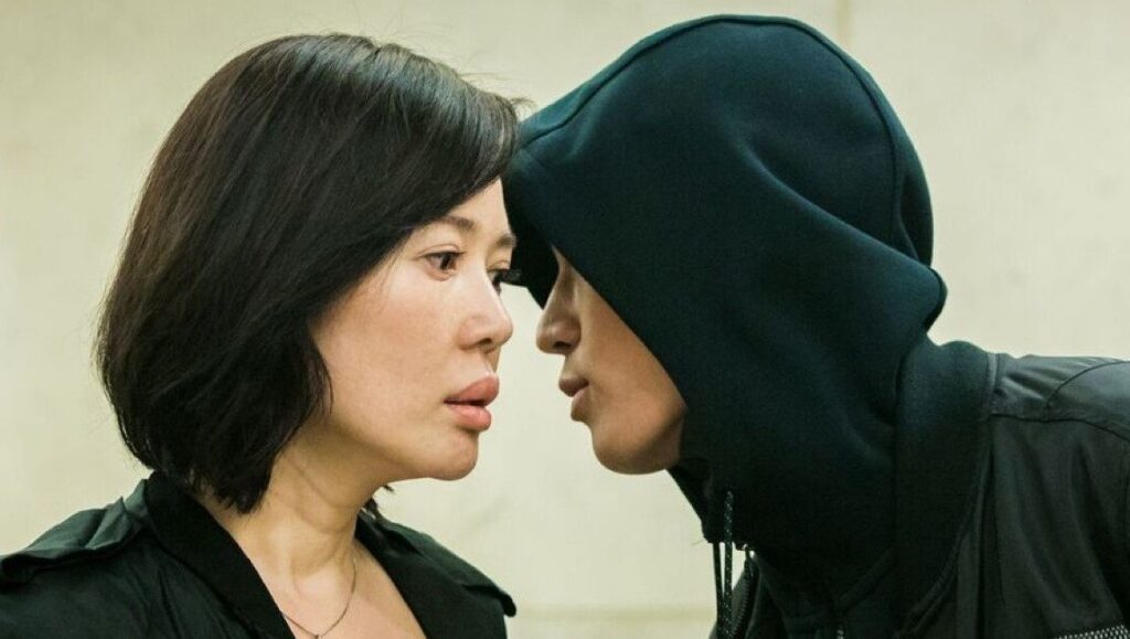 Blood of Youth film still. Woman and hooded figure face to face. Yang Shupeng movie scene.
