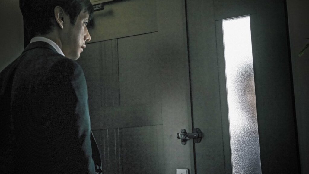 Creepy movie scene: Man near a door with a shadowy figure behind the frosted glass. Suspenseful thriller.