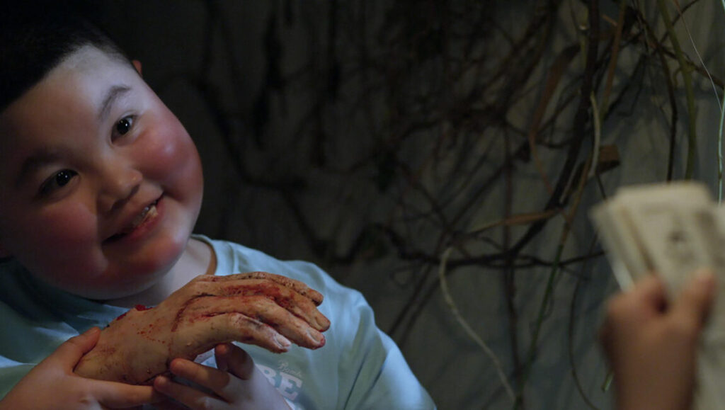 Kfc | Le Binh Giang Boy smiling, holding a fake bloody hand. Halloween costume at KFC Le Binh Giang.