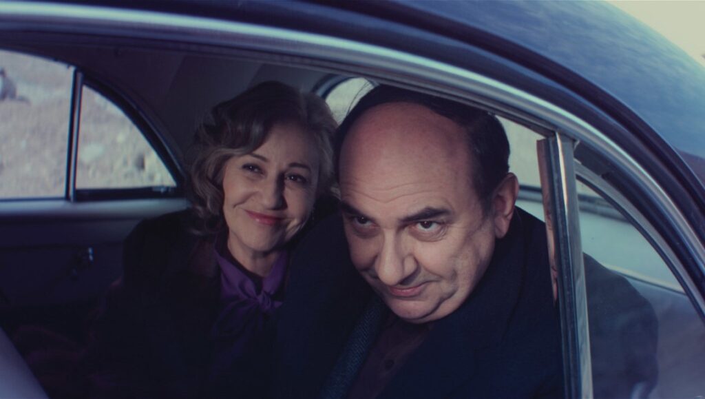 Neruda | Pablo Larrain Neruda film still. Man and woman inside a car in Pablo Larrain's Neruda.