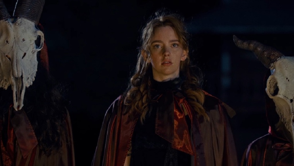 The Pale Door | Aaron B. Koontz The Pale Door movie scene. Woman surrounded by figures in cloaks and animal skulls. Horror film.