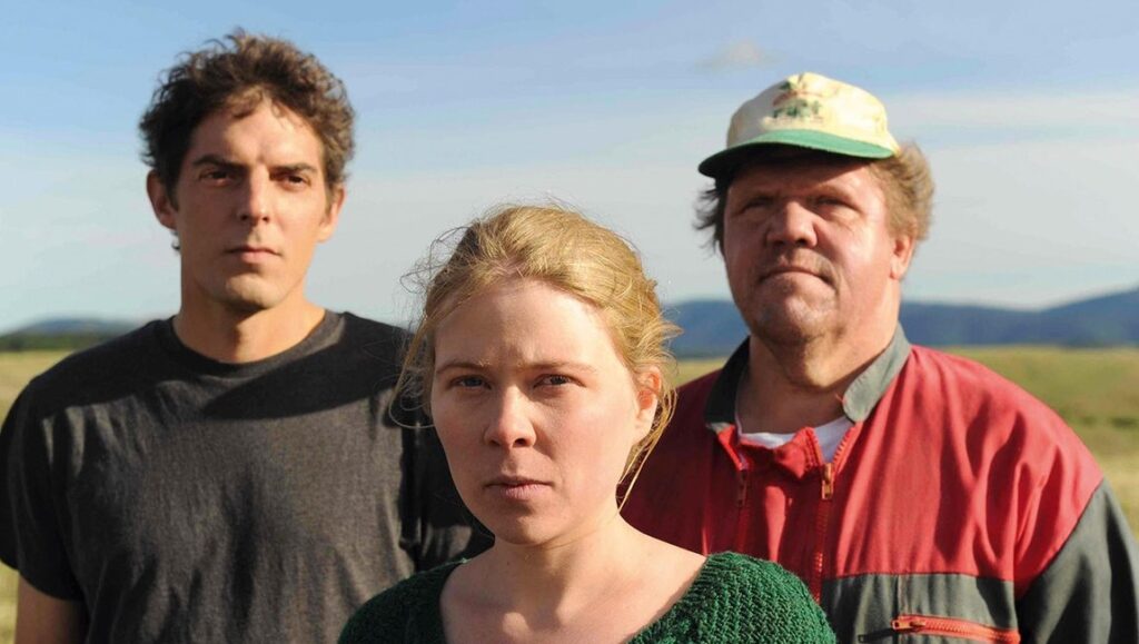 Alain Guiraudie's Staying Vertical film still. Three characters outdoors. Drama, French cinema.