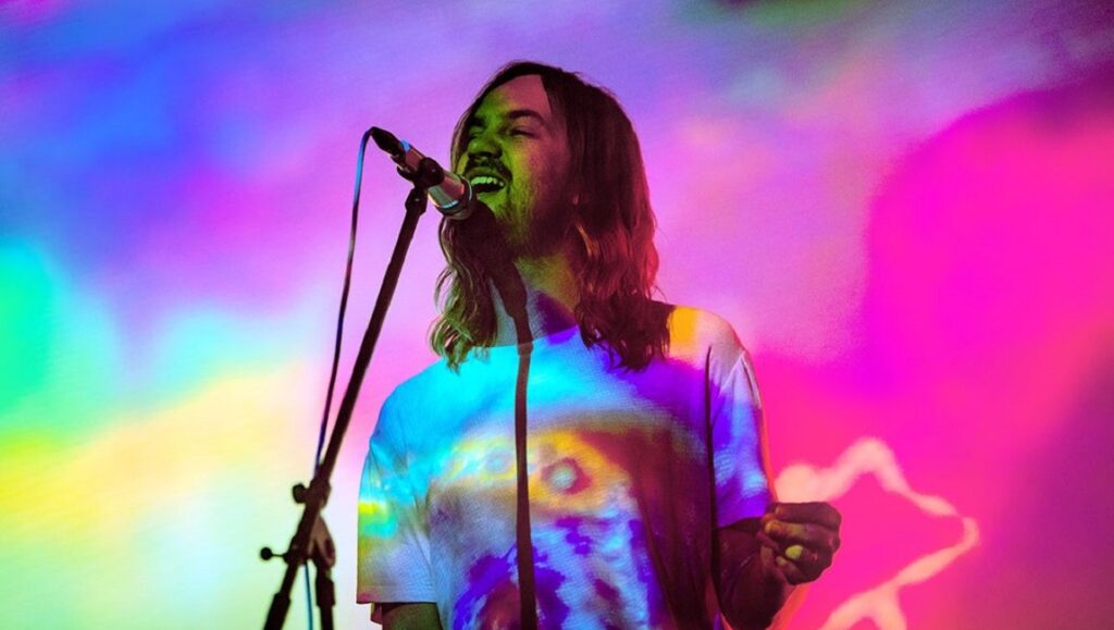 Tame Impala | The Slow Rush Tame Impala performing live. Kevin Parker singing on stage with colorful psychedelic lighting. The Slow Rush album.