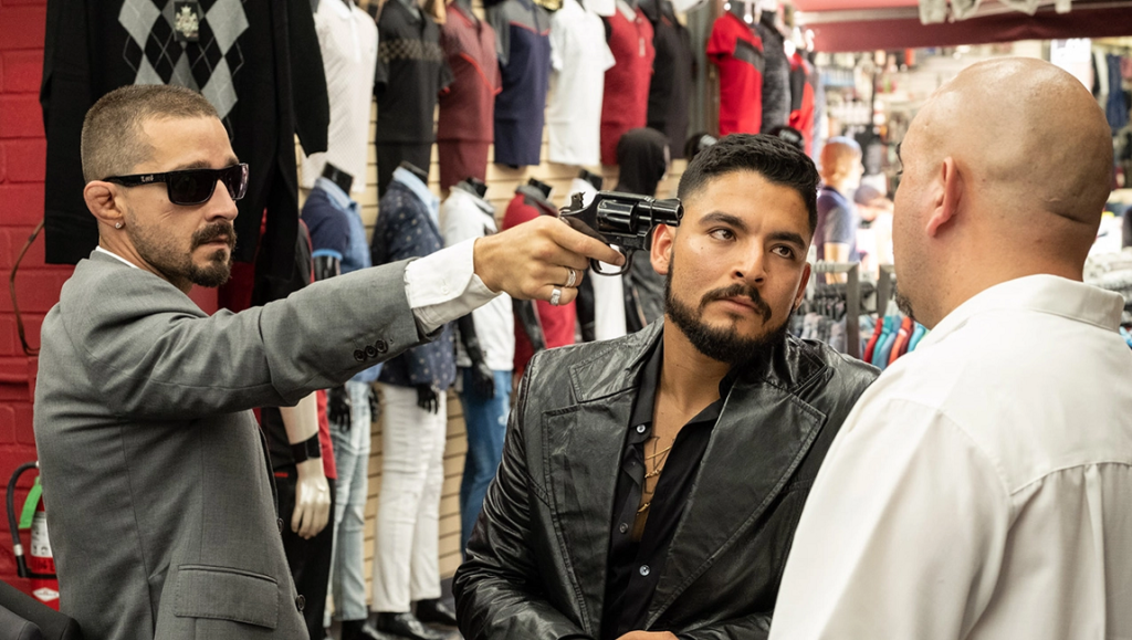 The Tax Collector movie scene. Shia LaBeouf points a gun at a man in a leather jacket.