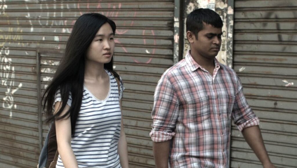 The Future Perfect film still: Nele Wohlatz directs two people walking in front of a metal wall.