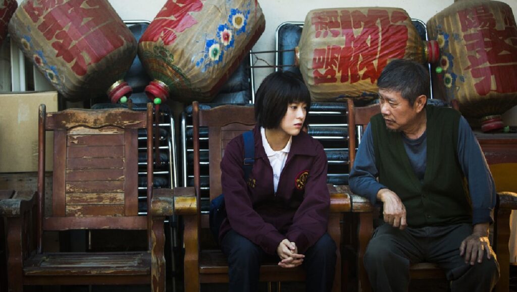 The Gangster’s Daughter | Chen Mei-juin Chen Mei-juin in The Gangster's Daughter movie. Father and daughter sitting on chairs. Lanterns in background.