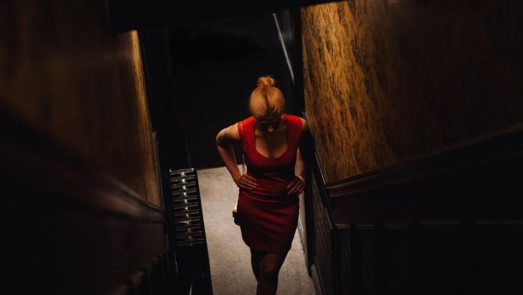 Woman in red dress on stairs. Lev Lewis, The Intestine series.