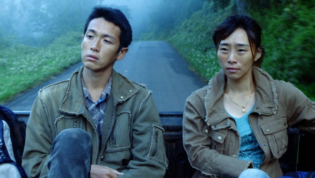 The Road to Mandalay: Burmese man and woman in Midi Z film, riding on a road.