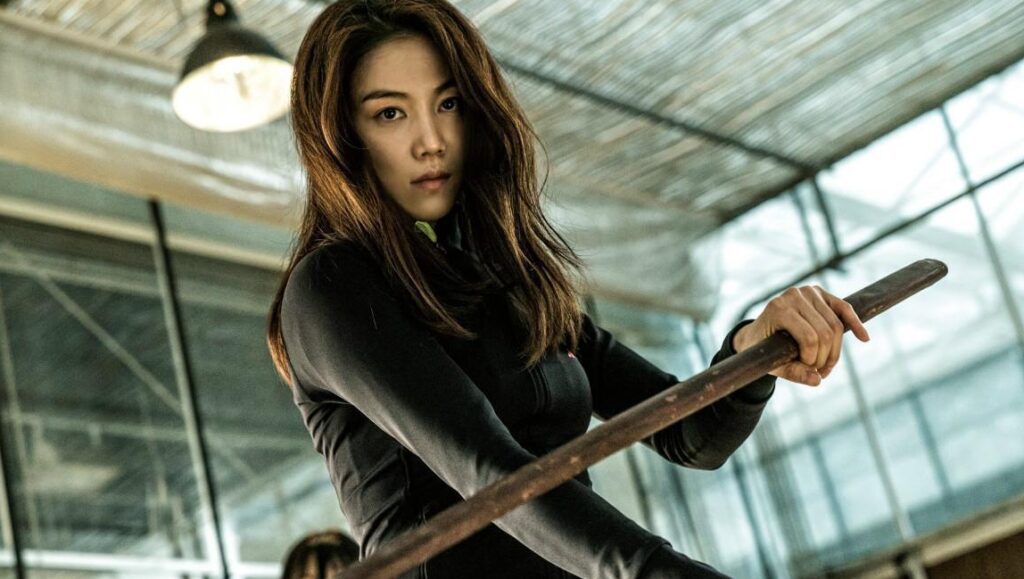 The Villainess movie still. Woman in black holds a wooden weapon. Jung Byung-Gil film.