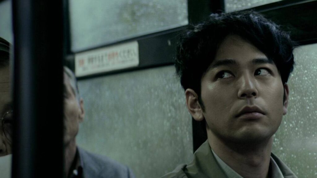 Kei Ishikawa in Traces of Sin. A man looks up with a concerned expression. Crime drama.