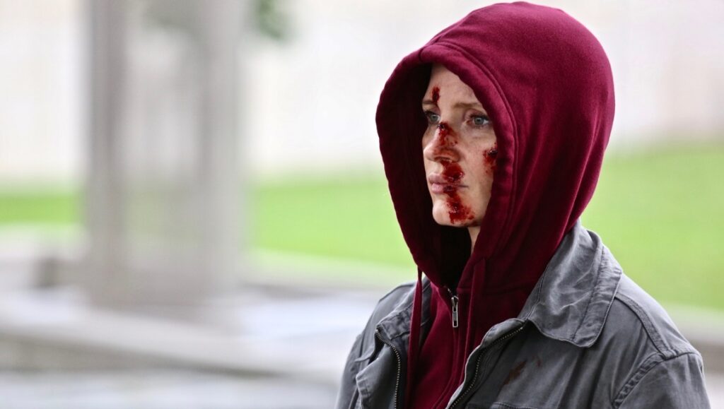 Jessica Chastain as Ava. Bloody face, hooded in a still from the Tate Taylor film. Action movie.