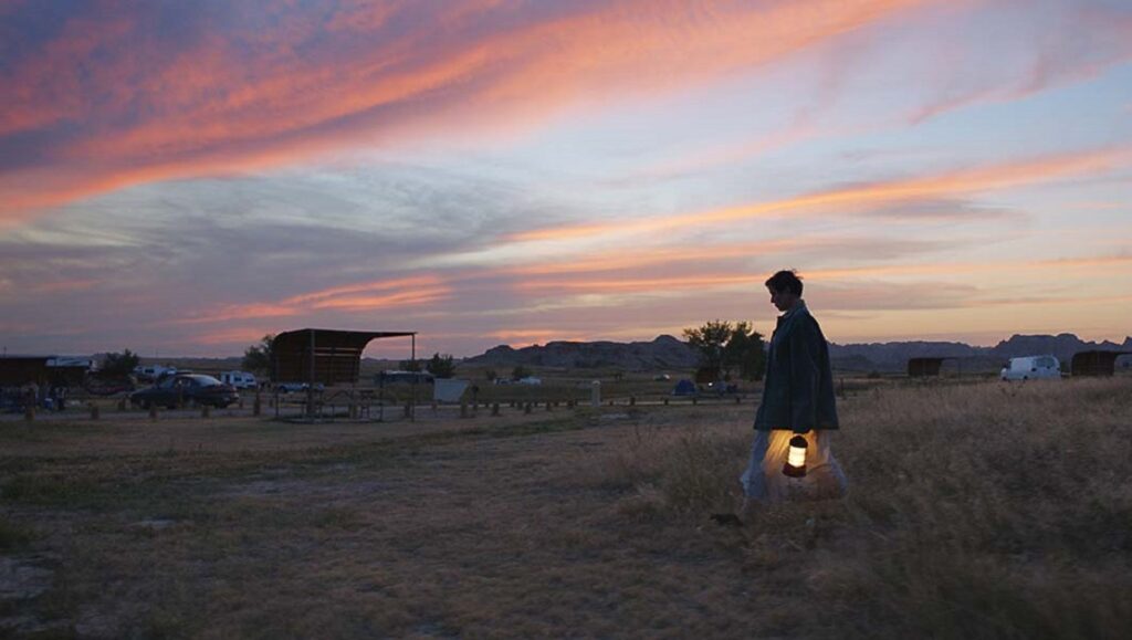 TIFF 2020 — Dispatch 1: Nomadland, One Night in Miami, American Utopia Nomadland TIFF 2020 film still. Woman with lantern at sunset in a campground. Indie film.