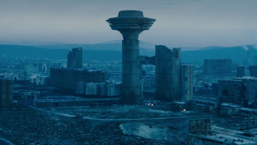 Fantasia Fest 2020 – Dispatch 6: Undergods, Sanzaru, #ShakespeareShitstorm Undergods film still: dystopian cityscape with ruins and a tower. Fantasia Fest 2020 film review.