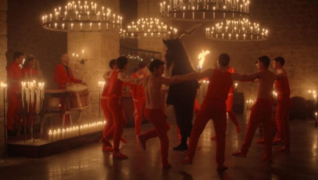 NYFF 2020: Scene from *Atarrabi and Mikelats*. Men in red dance around a bull figure, lit by candlelight.