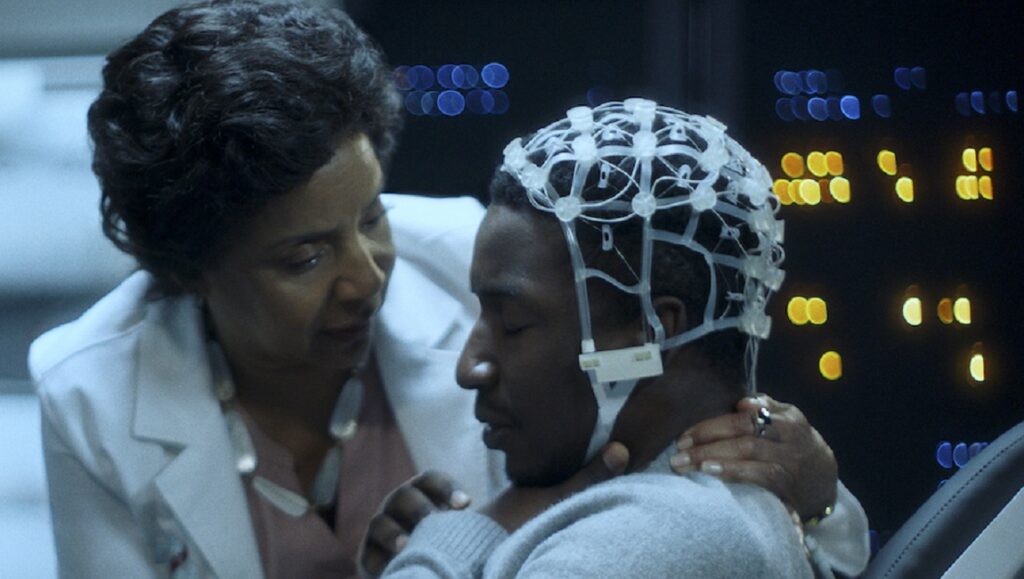 Black Box | Emmanuel Osei-Kuffour Black Box movie scene: Emmanuel Osei-Kuffour film. Man with EEG cap, doctor in lab coat. Science fiction, thriller.