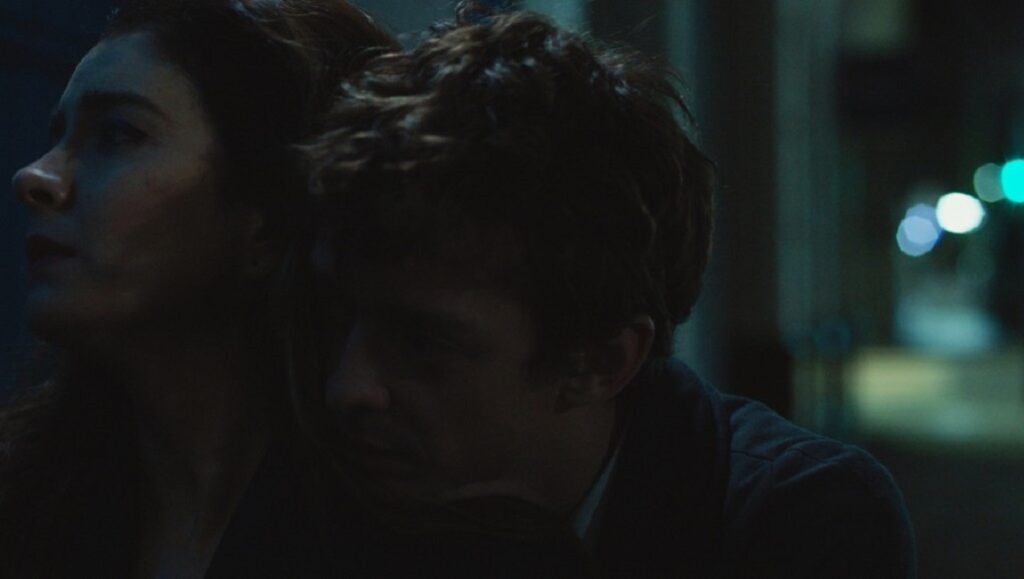 The Intruder | Natalia Meta The Intruder movie still: Natalia Meta film scene with two characters in a dimly lit, intimate moment.