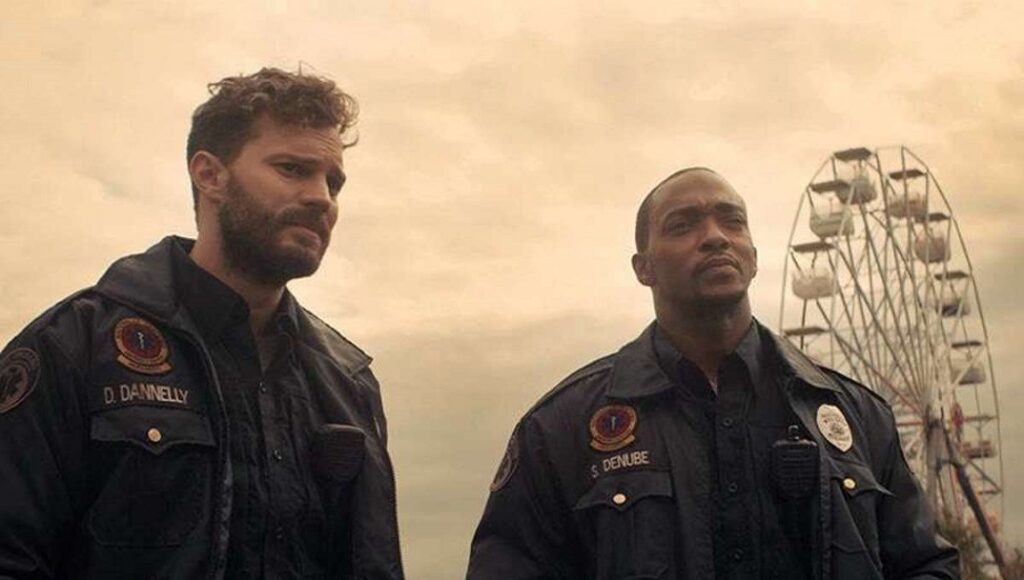 Synchronic | Justin Benson & Aaron Moorhead Synchronic movie still featuring Anthony Mackie and Jamie Dornan in uniform, with a Ferris wheel in the background.