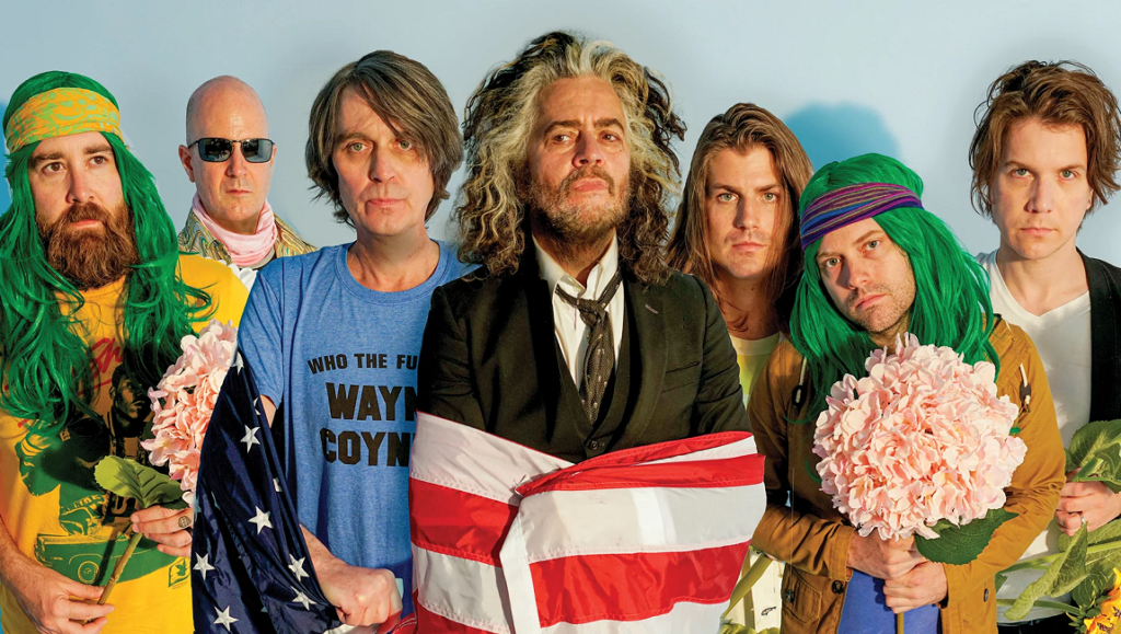 The Flaming Lips band members. Wayne Coyne wrapped in an American flag. American Head album.