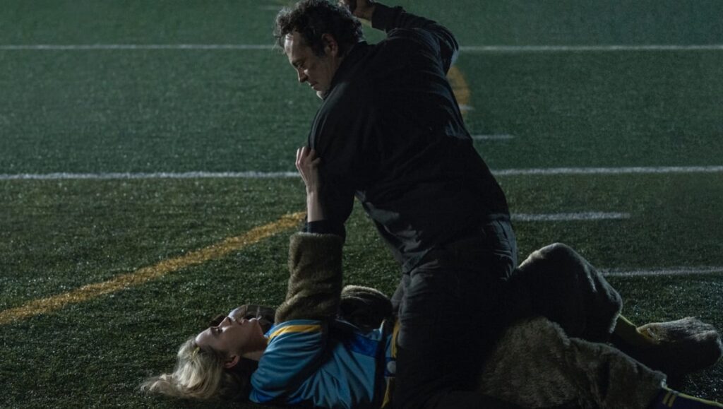 Freaky | Christopher Landon Freaky movie scene: A man with a knife attacks a woman on a football field. Horror film.