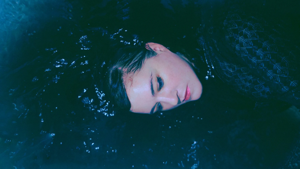 Julianna Barwick | Healing is a Miracle Julianna Barwick portrait. Singer-songwriter in dark water. Ledger Line Q3 2020 issue.