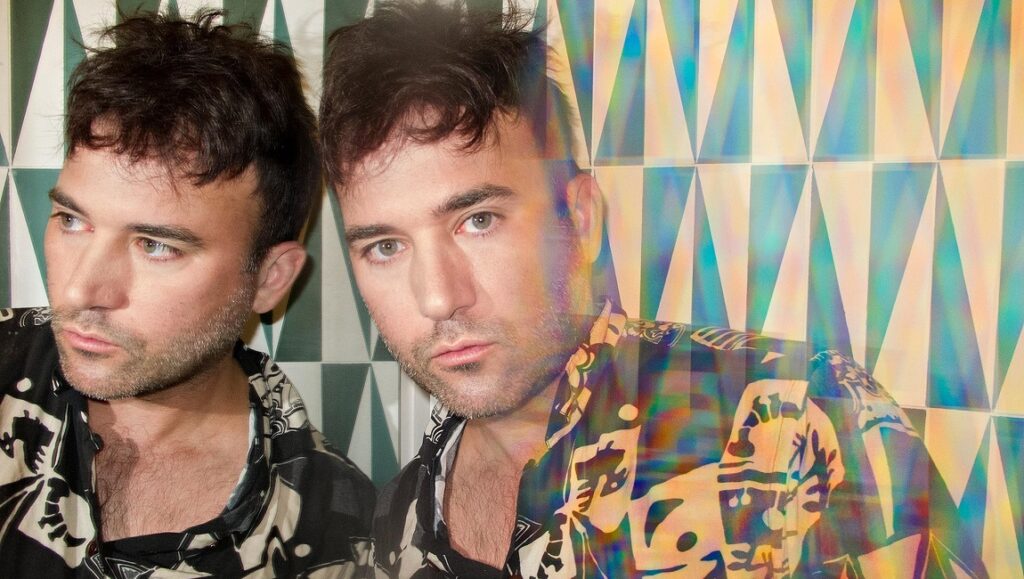 Sufjan Stevens, The Ascension album art. Singer with patterned shirt and geometric background.