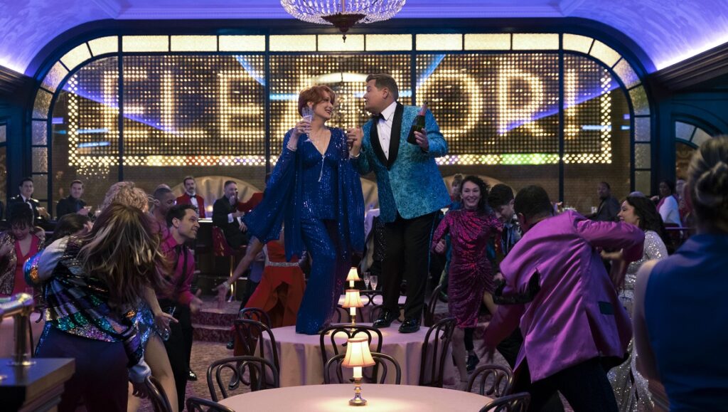 The Prom movie scene: Meryl Streep and James Corden dancing on a table at a party.