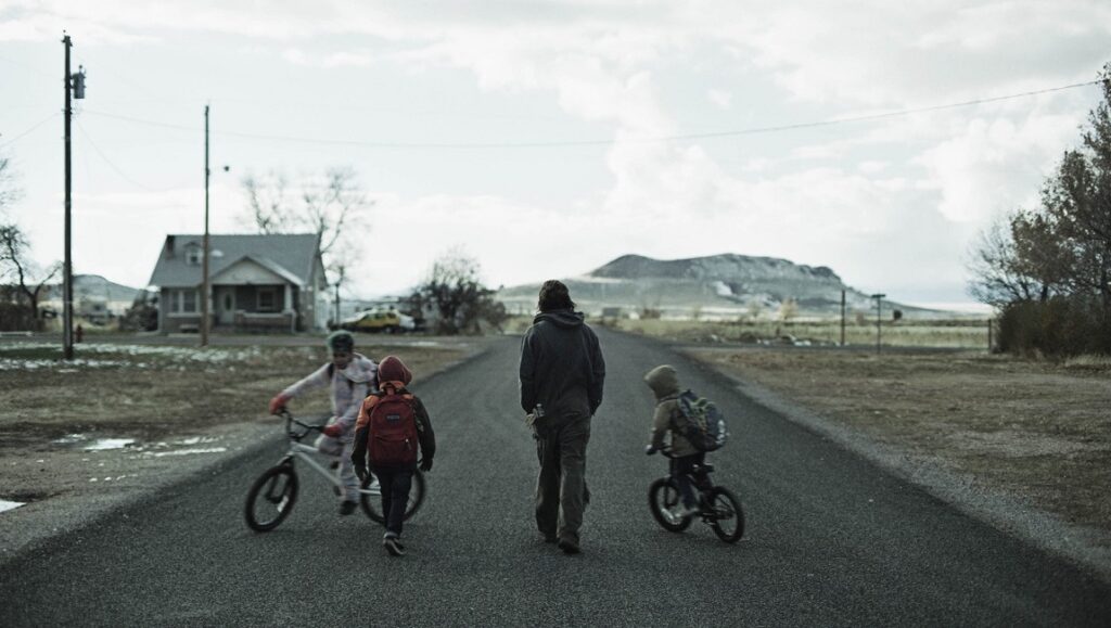 The Killing of Two Lovers | Robert Machoian The Killing of Two Lovers film still. Father walks with children on road. New Directors/New Films 2020.