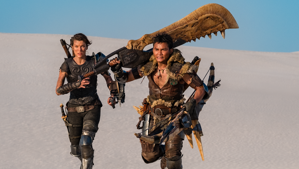 Monster Hunter | Paul W.S. Anderson Milla Jovovich and Tony Jaa in Monster Hunter movie. Action shot of hunters running in desert.