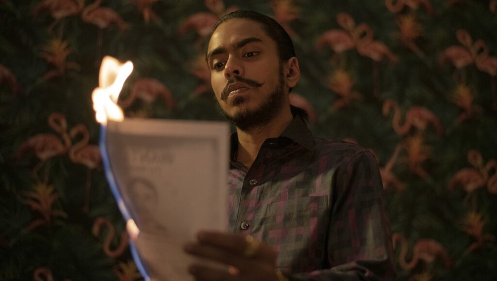 The White Tiger: Balram (Adarsh Gourav) burns a document. Drama, crime film.