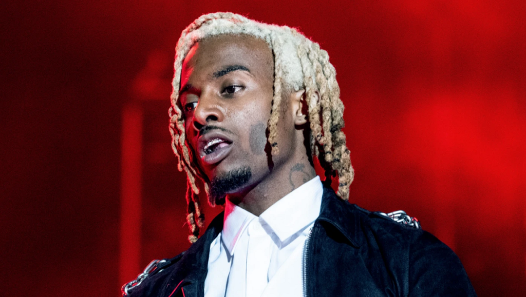 Playboi Carti | Whole Lotta Red Playboi Carti, Whole Lotta Red album art. Rapper with blonde dreads, wearing a black jacket and white shirt. Red background.