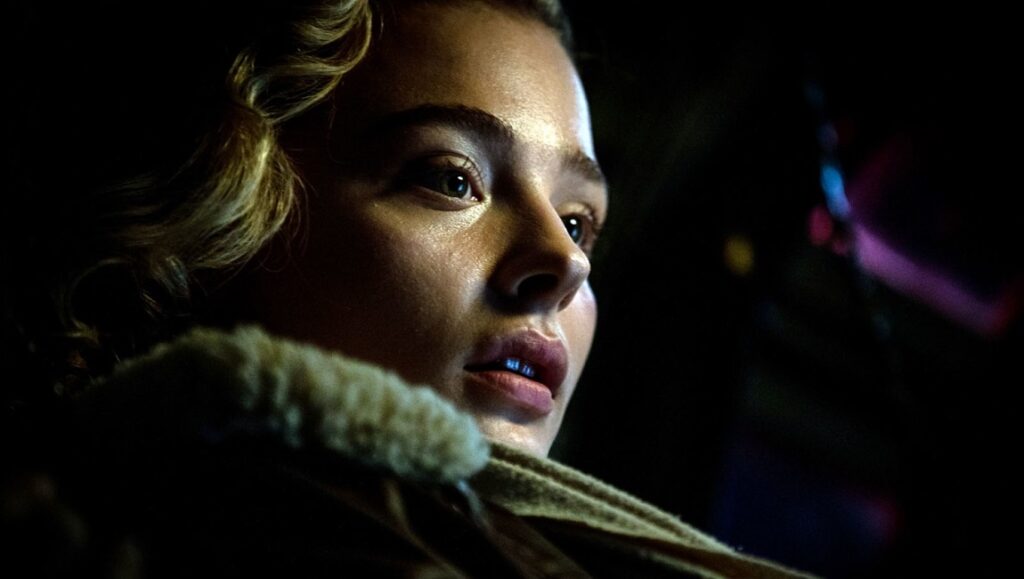 Shadow in the Cloud | Roseanne Liang Chloë Grace Moretz in Shadow in the Cloud. Close-up of the actress looking intently. WWII action horror film.