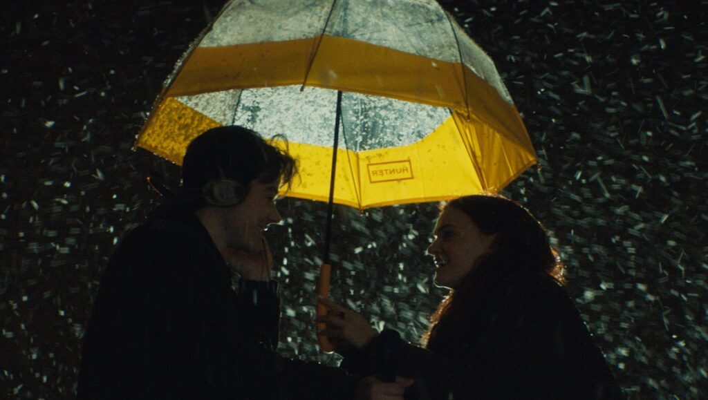 The Ultimate Playlist of Noise | Bennett Lasseter The Ultimate Playlist of Noise scene: couple under Hunter umbrella in the rain.